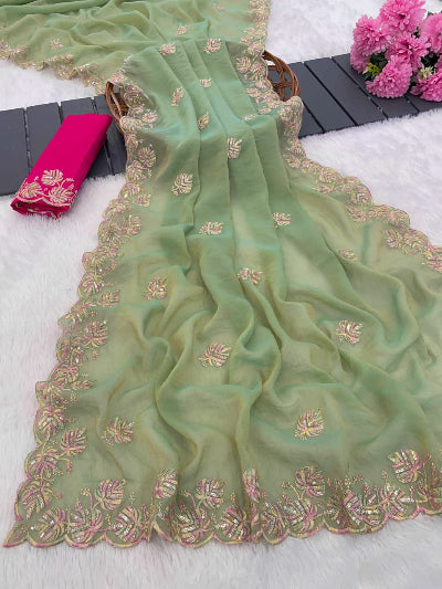 Green embroidered saree with pink flowers and a basket in the background