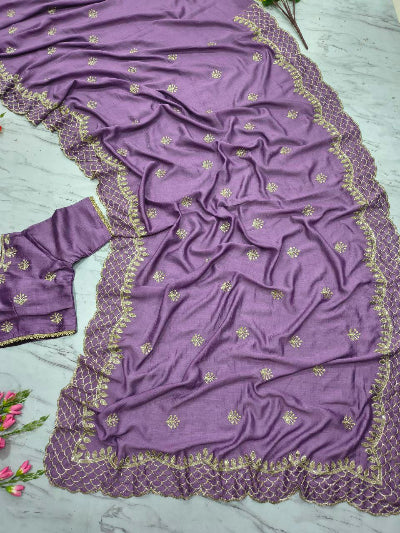 Purple saree with gold embroidery on a light gray background