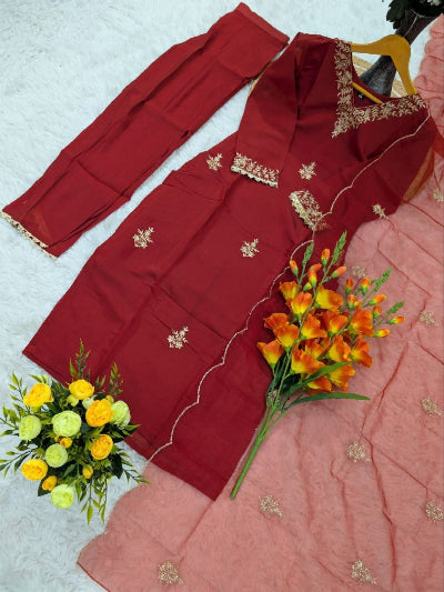 Red embroidered outfit with pink fabric and flowers on a light gray background