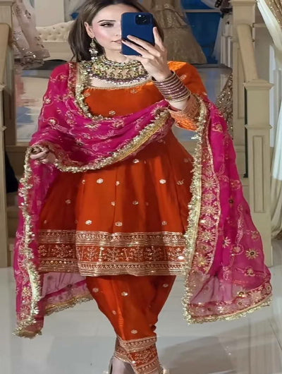 Woman in traditional orange and pink outfit with embroidery