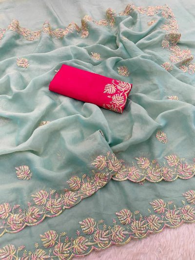 Light blue fabric with intricate gold embroidery and a pink folded fabric on top.